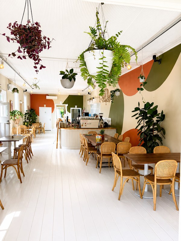 Buttery’s bright dining room with cane chairs, plants and colourful walls