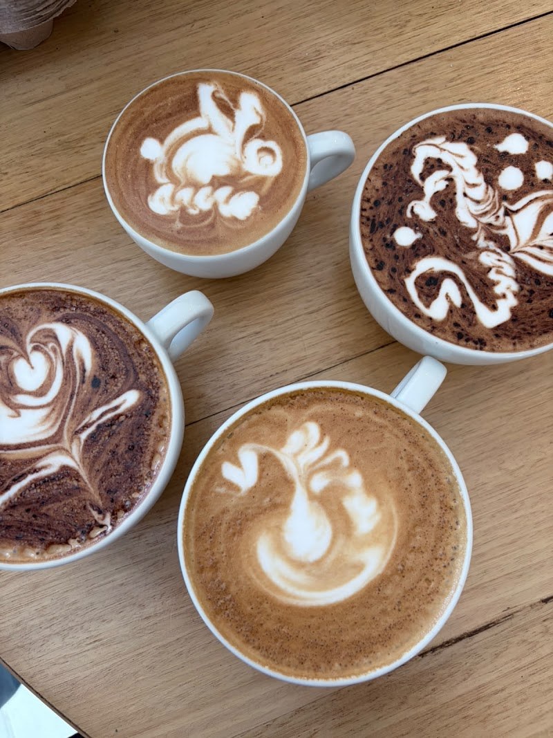 A table of coffees with latte art